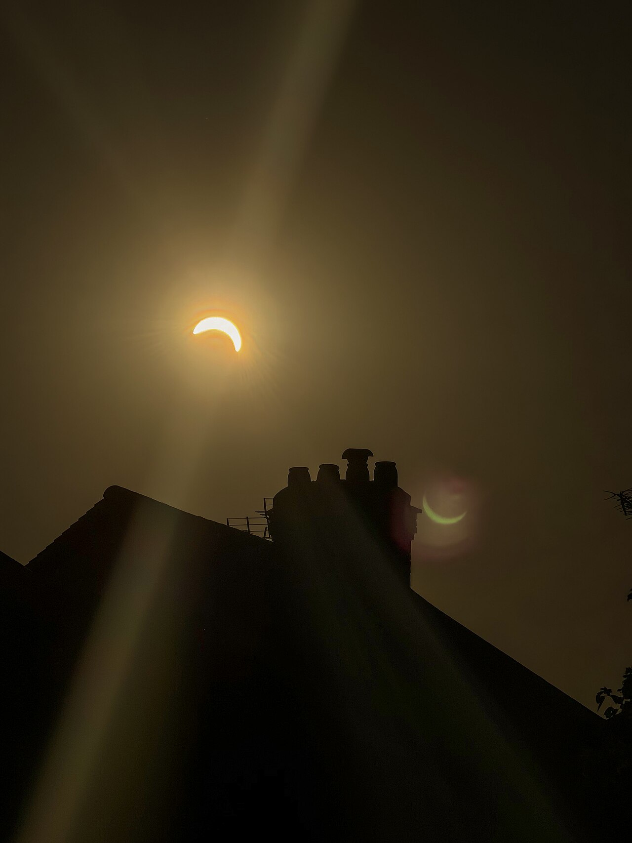 Partial solar eclipse glowing above silhouetted rooftops in West London on 12 August 2026